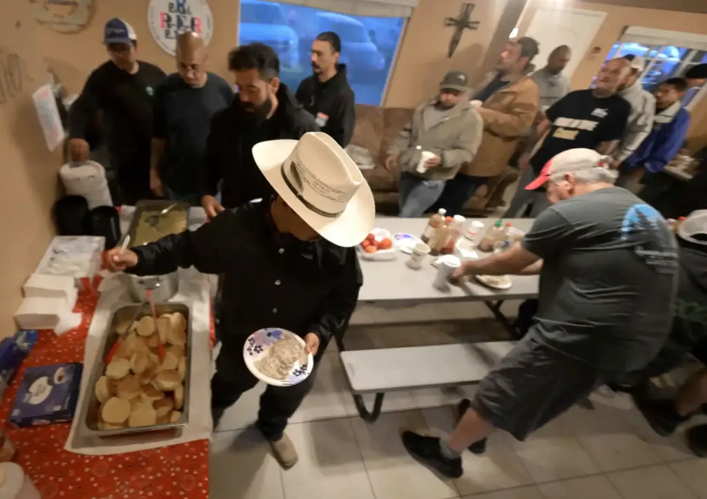 “Ranchersâ line up to receive breakfast before sunrise on Friday,...