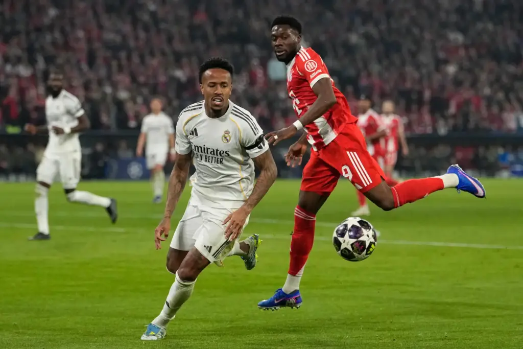 Real Madrid's Eder Militao, left, challenges for the ball with Bayern's Alphonso Davies