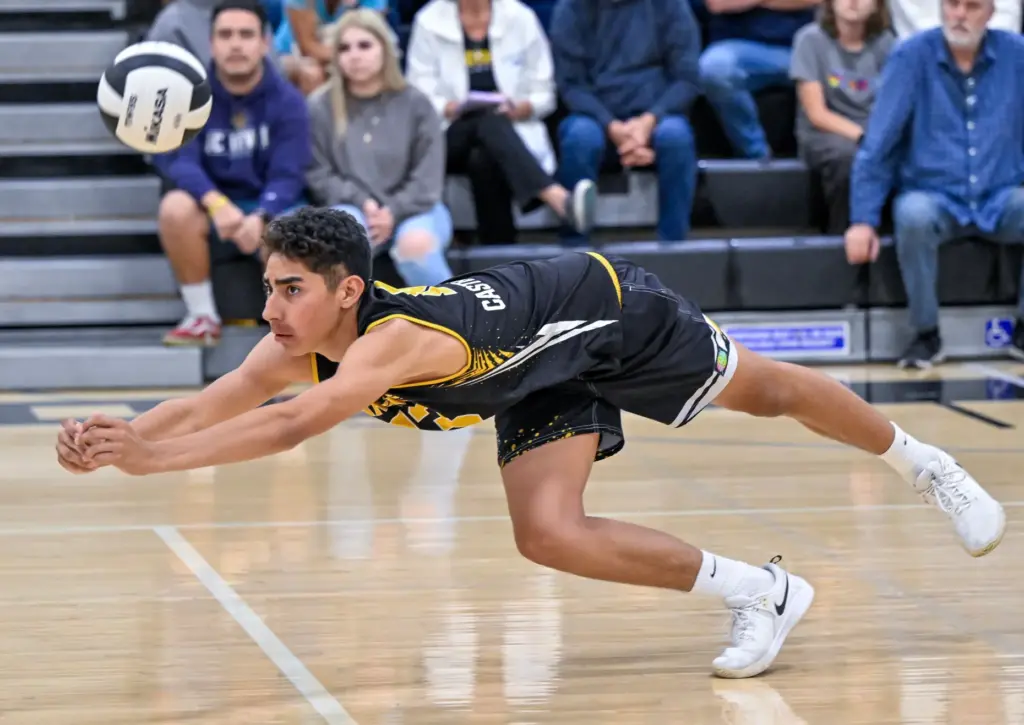 Foothill opposite hitter Eddie Castellanos dives to dig the ball...