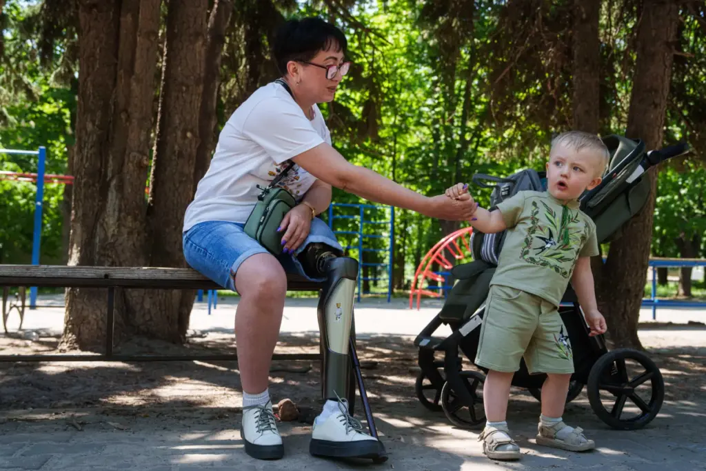Iryna Nakonechna plays with her grandson Tymofii in a park of Kryvyi Rih, Ukraine.