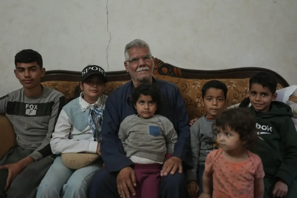 Yusuf Abu poses for a photo with his grandchildren