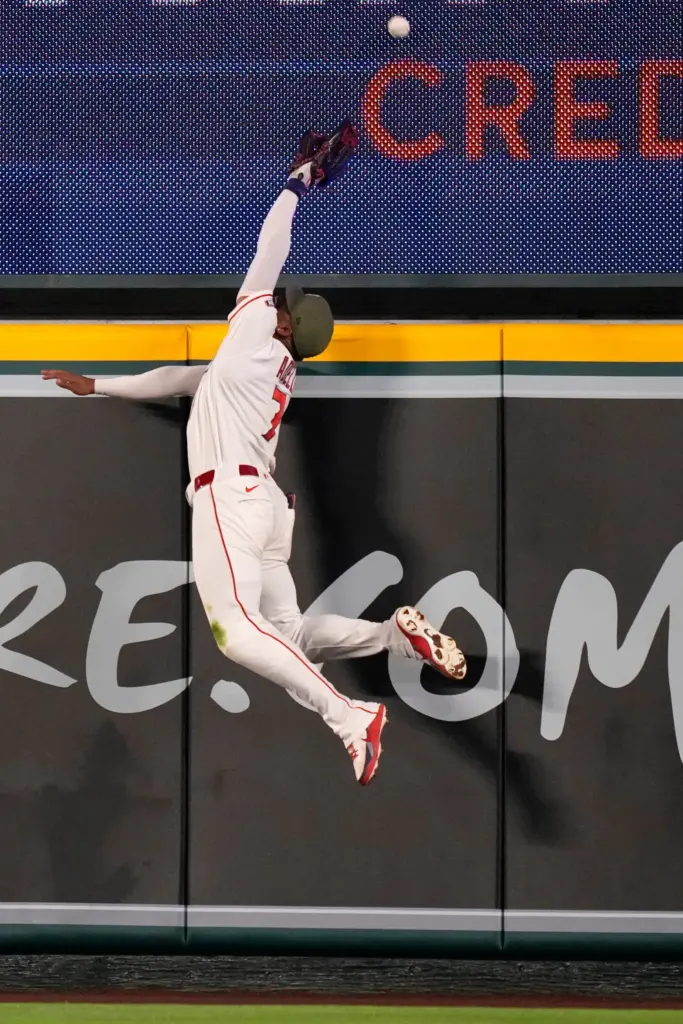 Angels right fielder Jo Adell leaps but can’t get to...