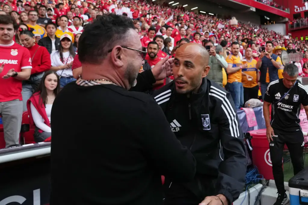 Tigres’ coach Guido Pizarro, right, greets Toluca’s coach Antonio Mohamed...