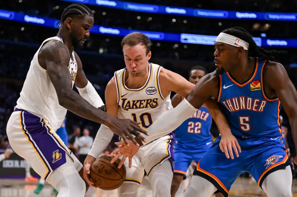 Lakers center Deandre Ayton, left, and guard Luke Kennard, middle,...