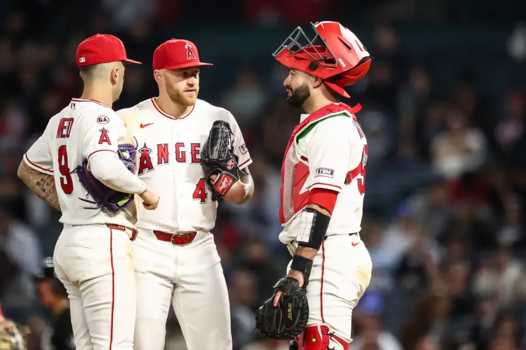 Angels relief pitcher Sam Bachman, center, meets with shortstop Zach...