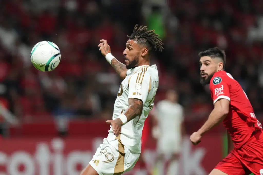LAFC’s Denis Bouanga, left, goes for the ball as Toluca...