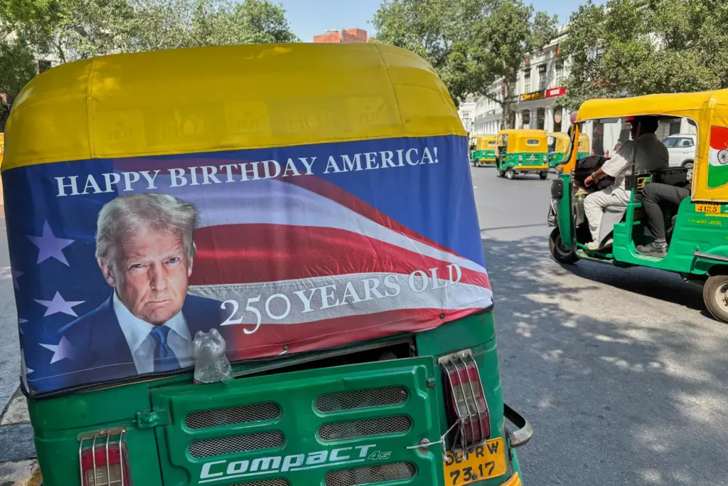 An auto-rickshaw displays a poster of President Donald Trump.