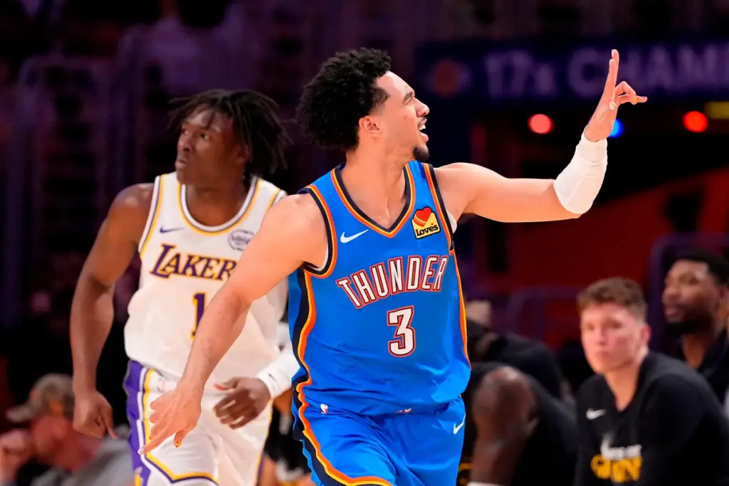Oklahoma City Thunder guard Jared McCain, right, gestures after scoring...