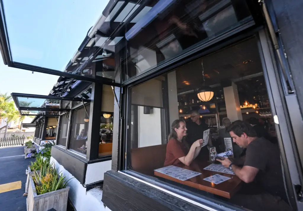 Corey Walker and Courtney Wann sit by an open window...