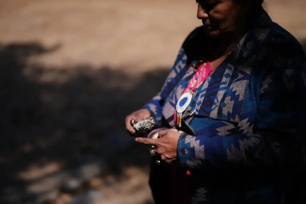 Norma Meza Calles, a Kumeyaay Nation leader, lights a bundle...