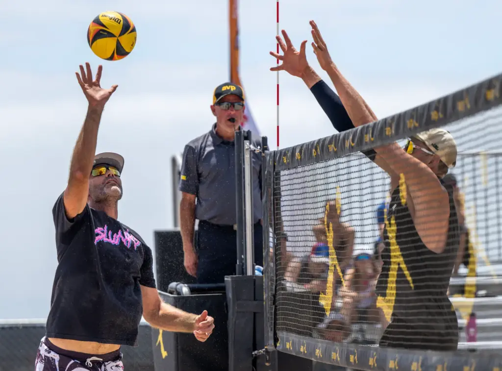 Phil Dalhausser, left, tips the ball over the block of...
