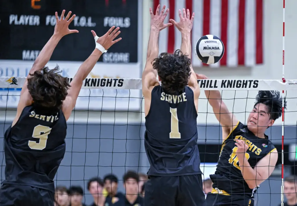 Foothill outside hitter Max Chang, right, hits the ball down...