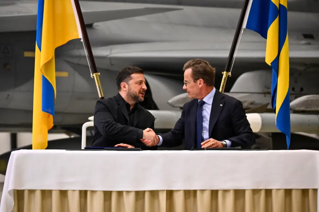 Sweden's Prime Minister Ulf Kristersson and Ukraine's President Volodymyr Zelenskyy shake hands.