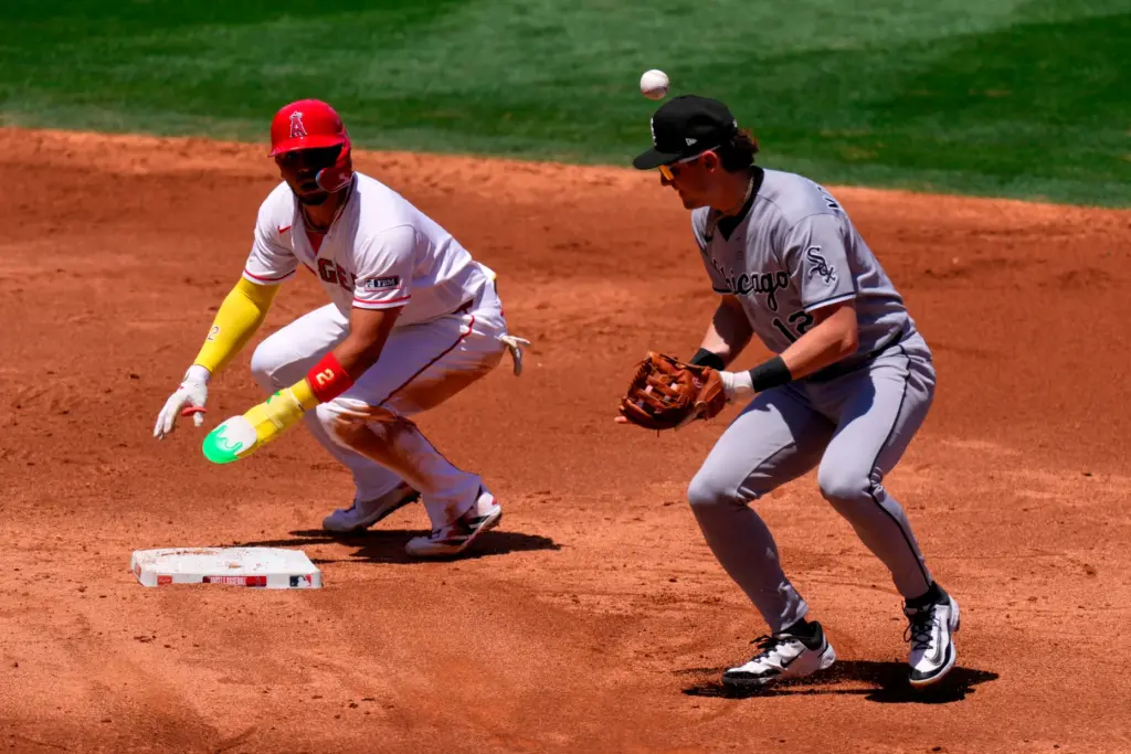 Chicago White Sox shortstop Colson Montgomery, right, bobbles the ball...