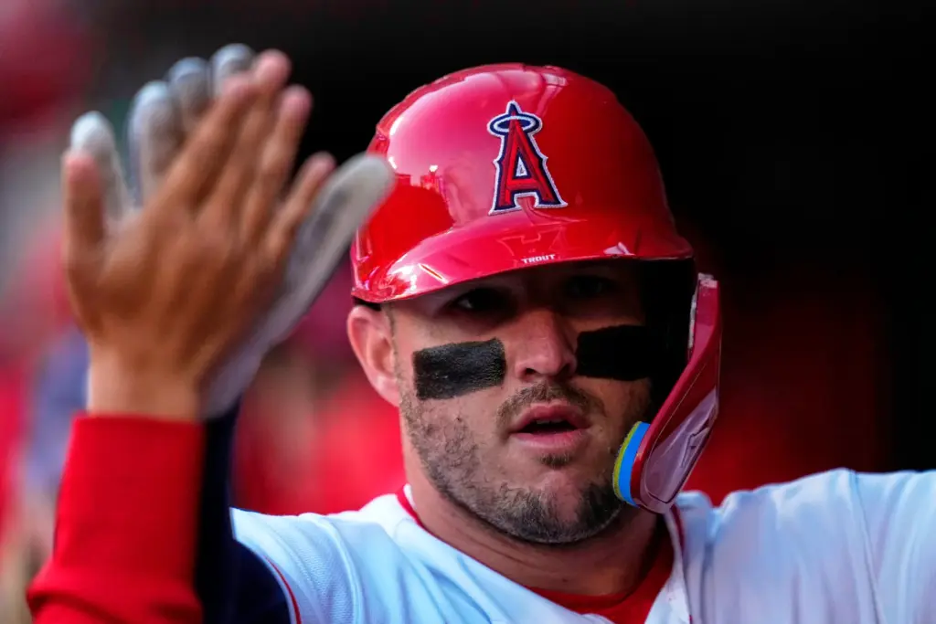 Angels star Mike Trout is congratulated by teammates in the...
