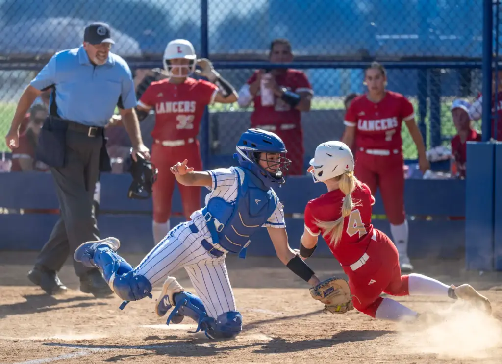 Orange Lutheran catcher Eliana Corona, left, tags Orange Lutheran outfielder...