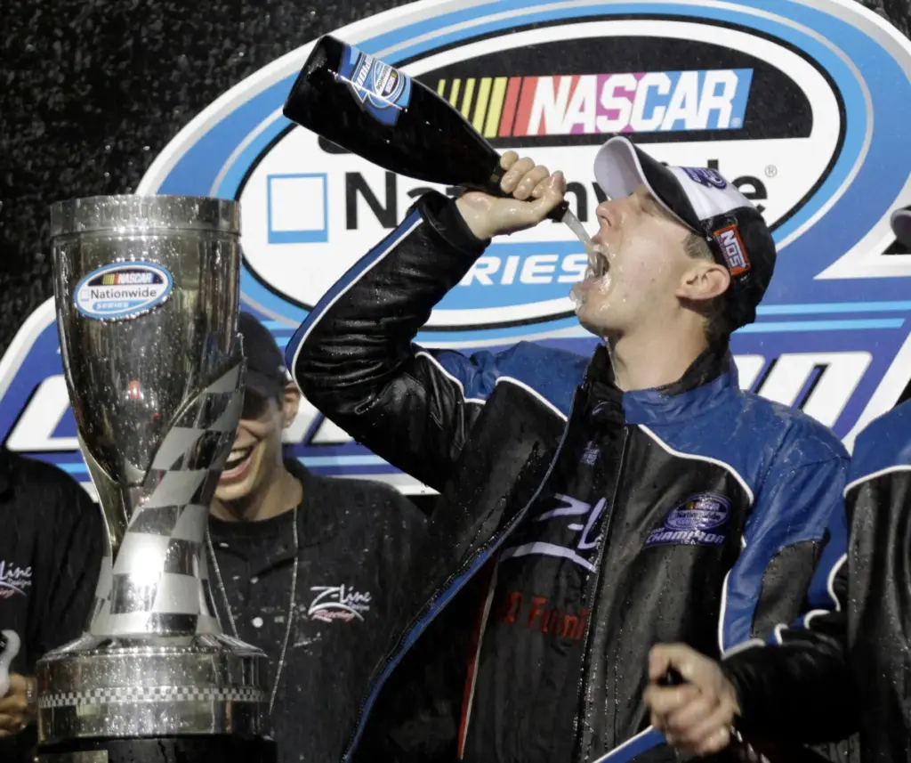 Kyle Busch drinks champagne after winning the Nationwide series championship.