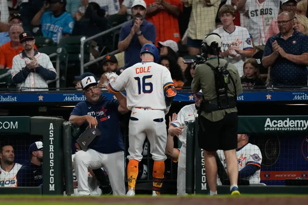The Houston Astros’ Zach Cole returns to the dugout after...