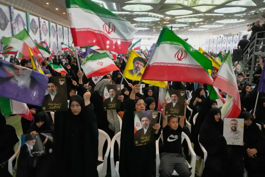 Government supporters hold Iranian flags and pictures of Iran’s Supreme...