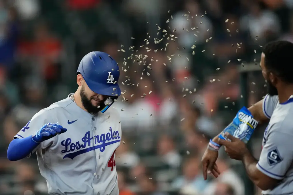 The Dodgers’ Andy Pages, left, gets a sunflower seed shower...