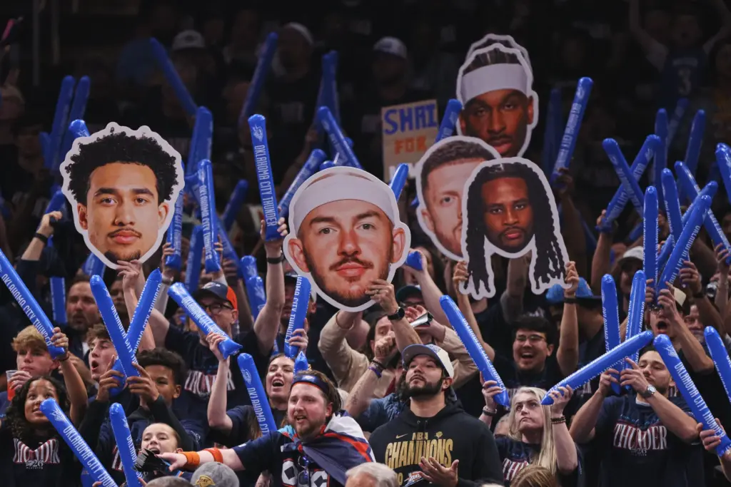 Fans cheer and others hold up photo cut-outs of Oklahoma...
