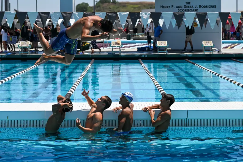 Andrew Maksymowski of Northwood High School jumps over his teammates...