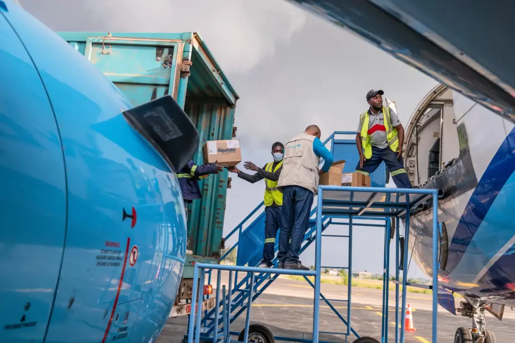 People offload a shipment of more than 15 tons of supplies for the Ebola outbreak.