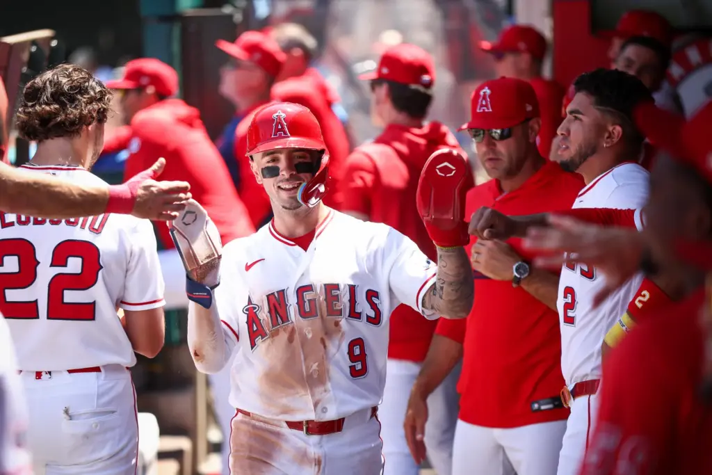 The Angels’ Zach Neto celebrates with teammates in the dugout...