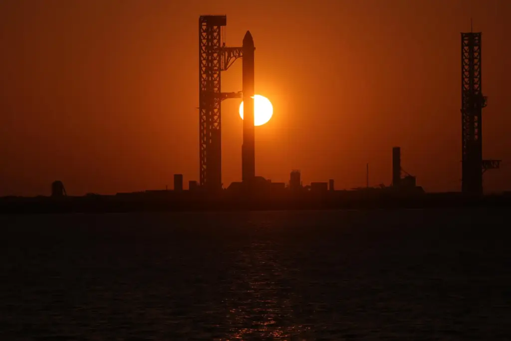 The sun rises behind SpaceX’s mega rocket Starship as it...