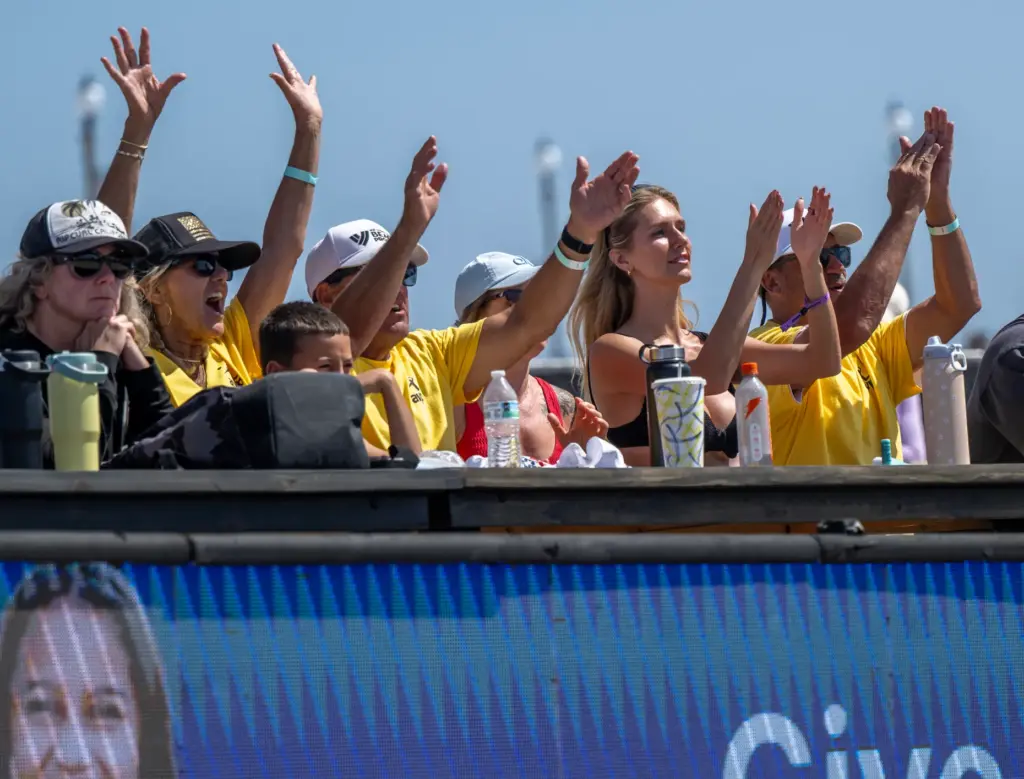 Fans cheer on beach volleyball players while watching a quarterfinal...