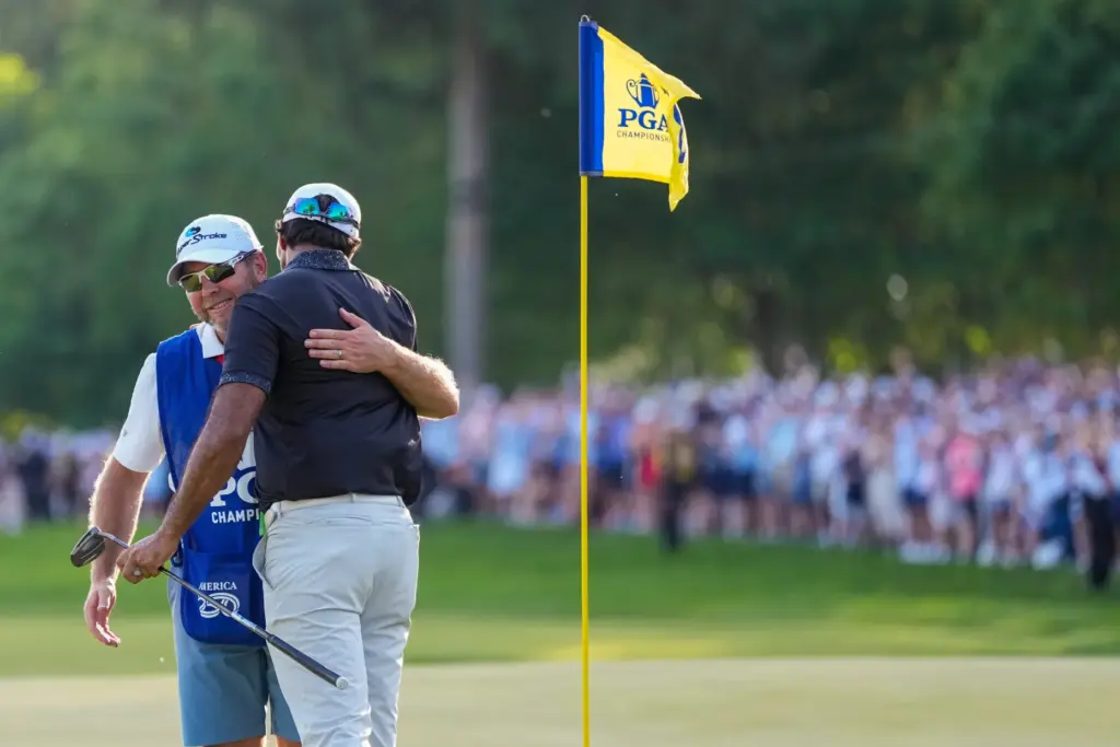 Aaron Rai, of England, embraces his caddie after his round...