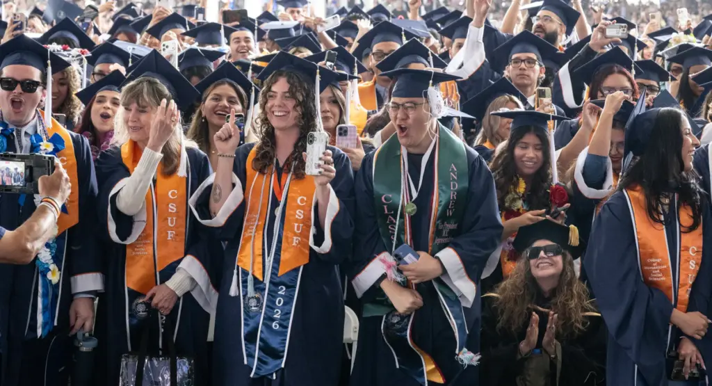 Students do the ceremonial tassel move — from the right...