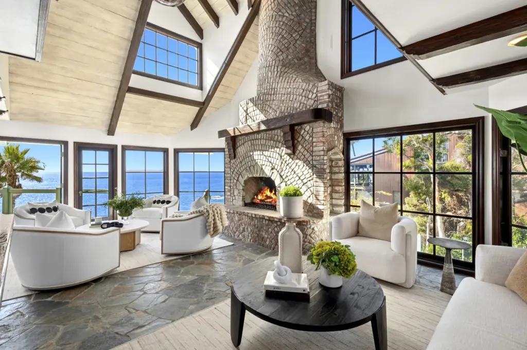 A brick fireplace with a heavy timber mantle anchors the...