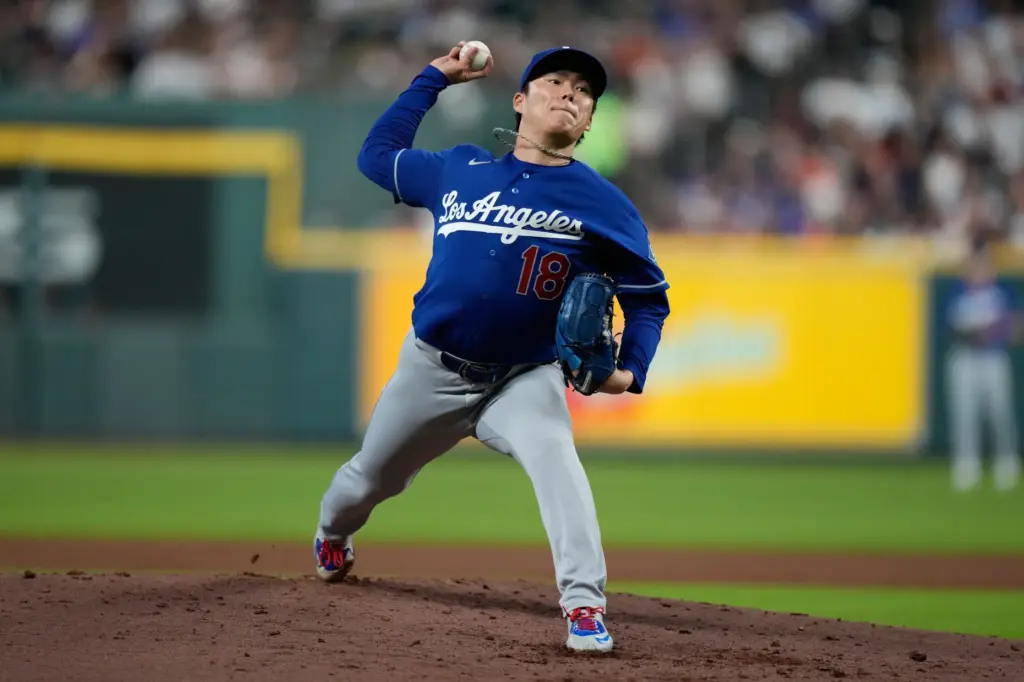 Dodgers starting pitcher Yoshinobu Yamamoto throws to the plate during...