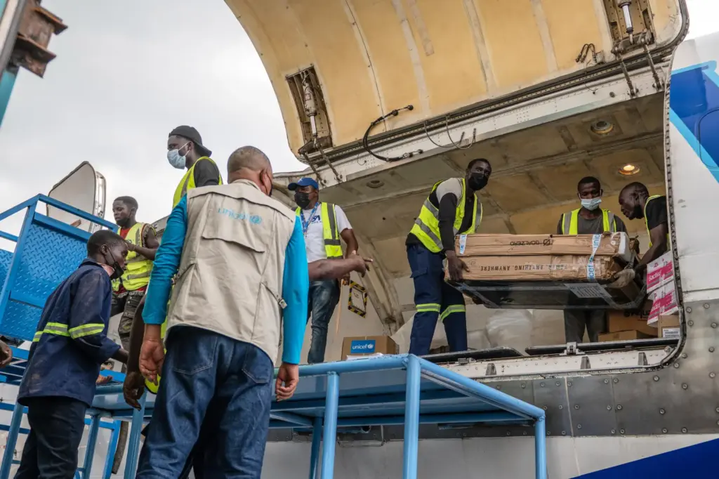 People offload a shipment of more than 15 tons of supplies for the Ebola outbreak.