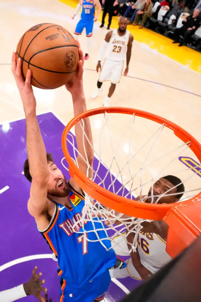 Oklahoma City Thunder center Chet Holmgren, left, dunks as Lakers...