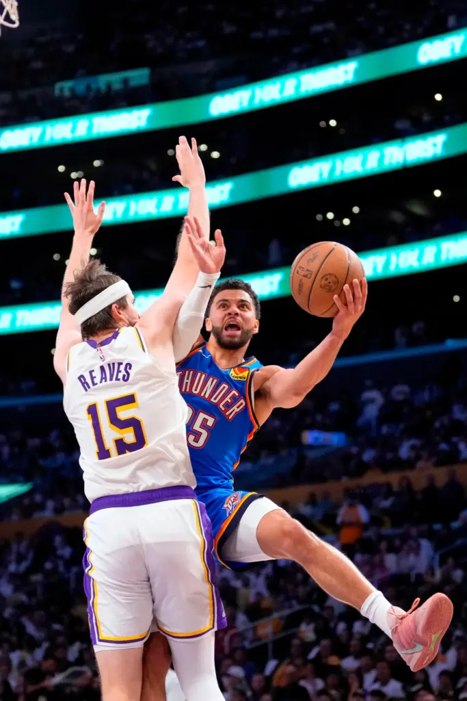 Oklahoma City Thunder guard Ajay Mitchell, right, shoots as Lakers...
