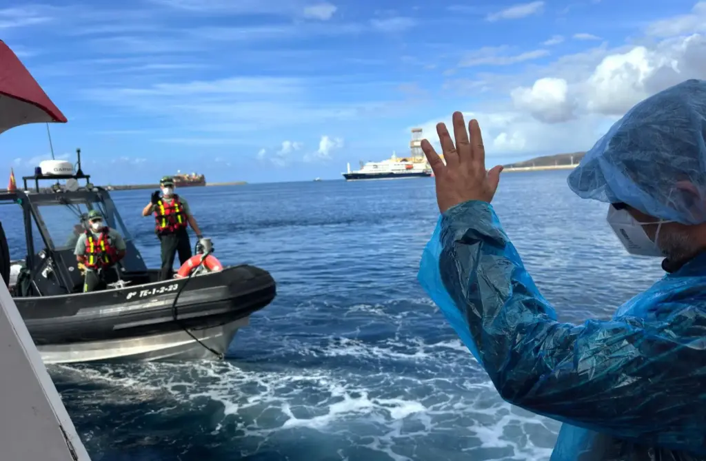 A passenger waves to the Guardia Civil officers as they...