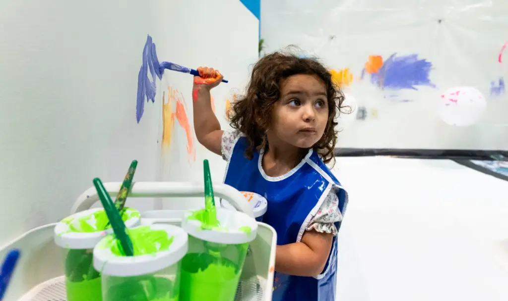 Avah Shahi, 2, paints the walls during opening day of...