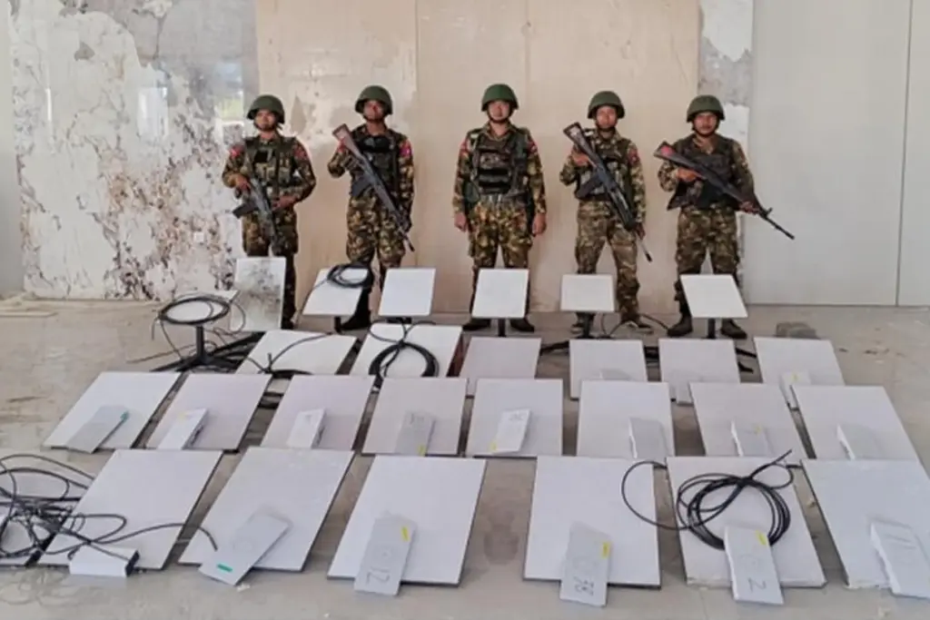 Soldiers stand next to Starlink satellite internet devices.