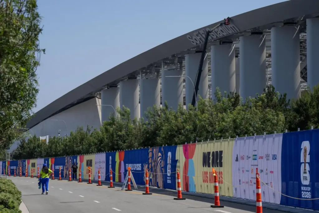 A person walks past temporary fencing with FIFA World Cup...
