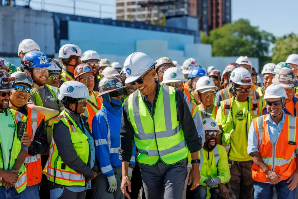 Former President Barack Obama talks with workers while visiting the...