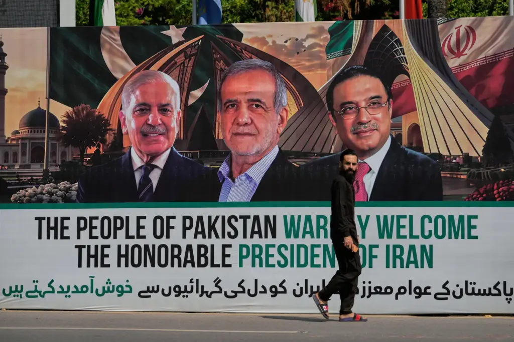 A man walks past a welcoming billboard in Islamabad.