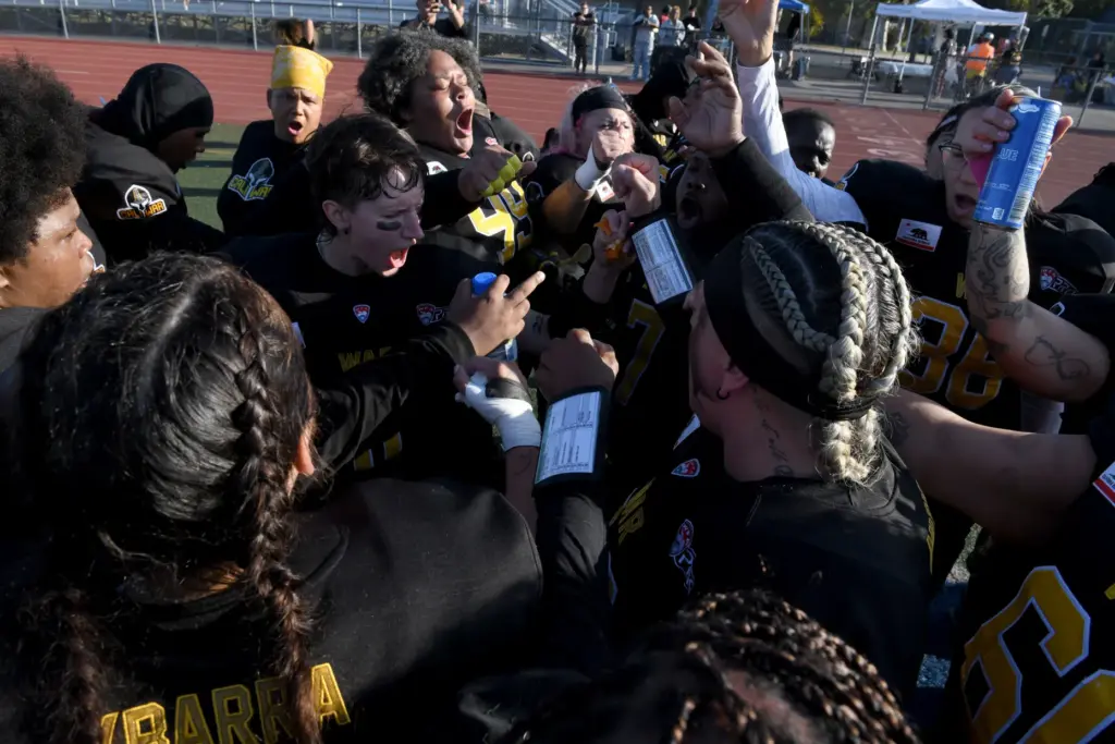 The CaliWar women’s football team huddles during a time out...