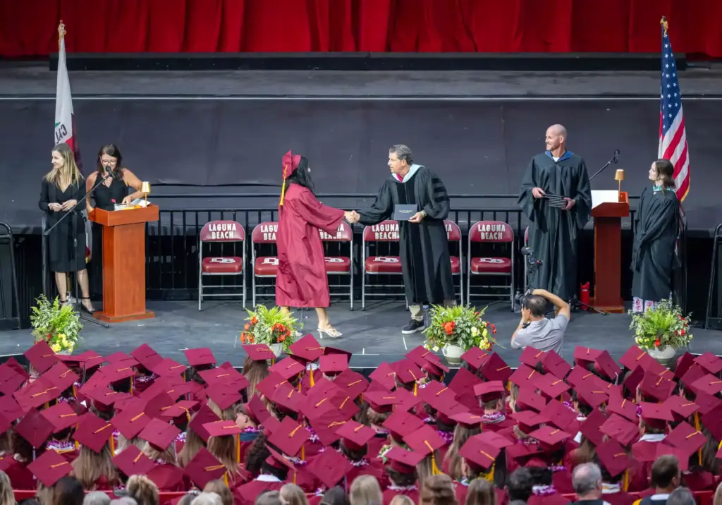 Olivia Brenes shakes hands with Principal Jason Allemann as she...