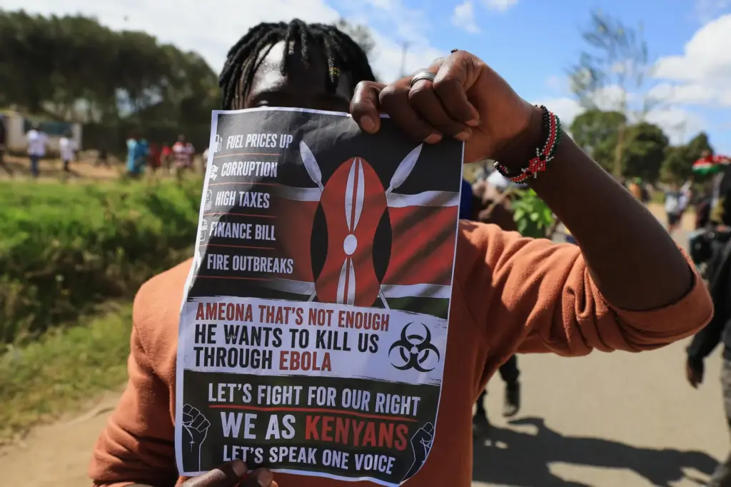 A protester holds up a placard during a demonstration against a proposed Ebola quarantine center.