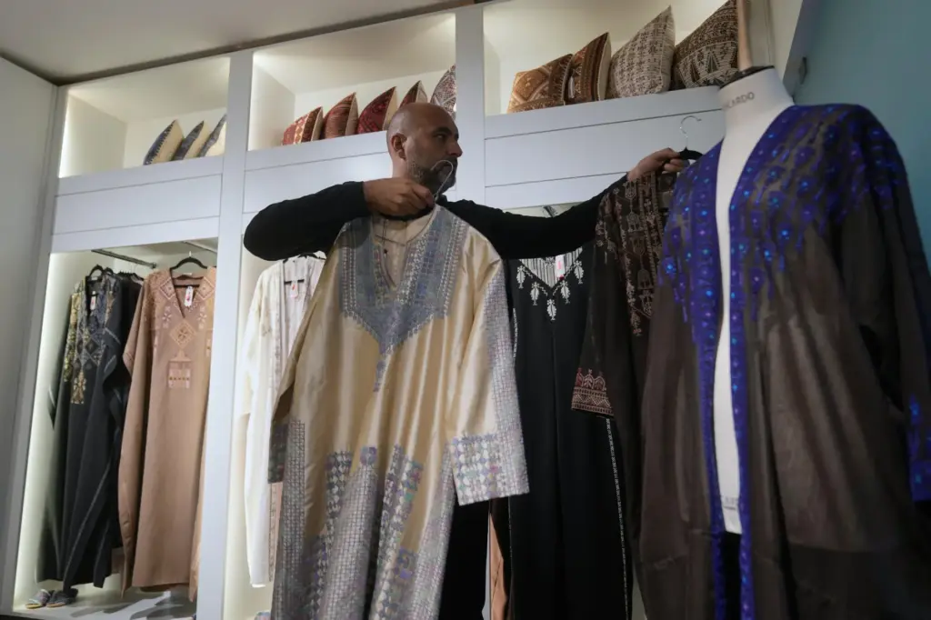 Ali Jaafar, the general manager of Inaash Association, arranges clothes...