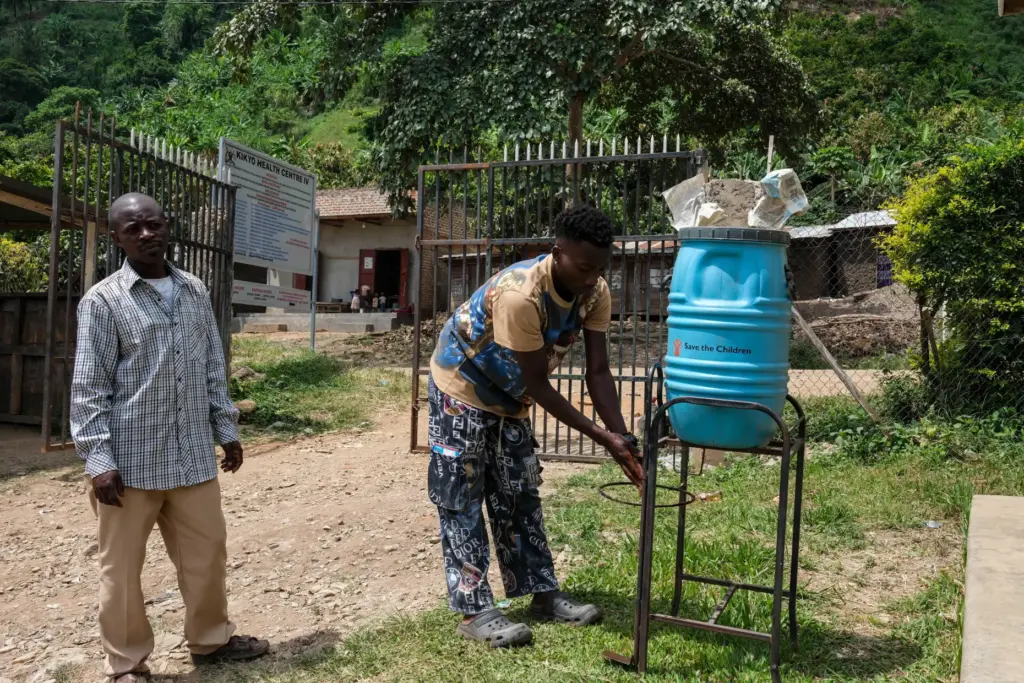People wash their hands before entering Kikyo Health Centre IV.