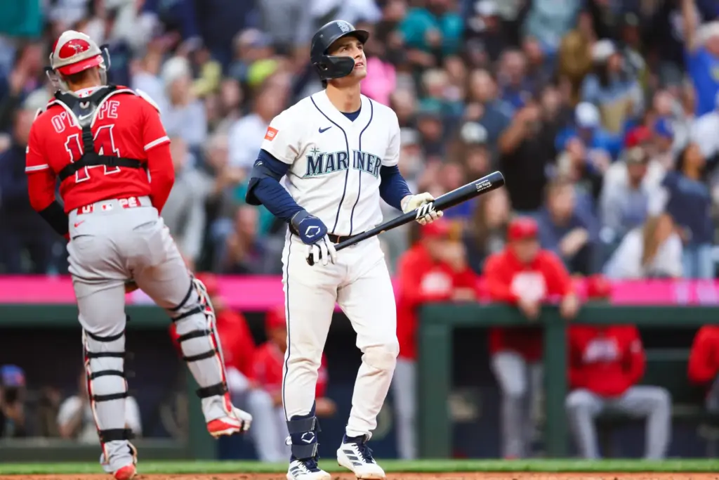 The Seattle Mariners’ Cole Young watches the flight of his...