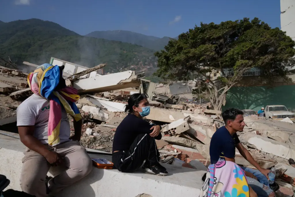 Residents sit near their destroyed homes two days after an...